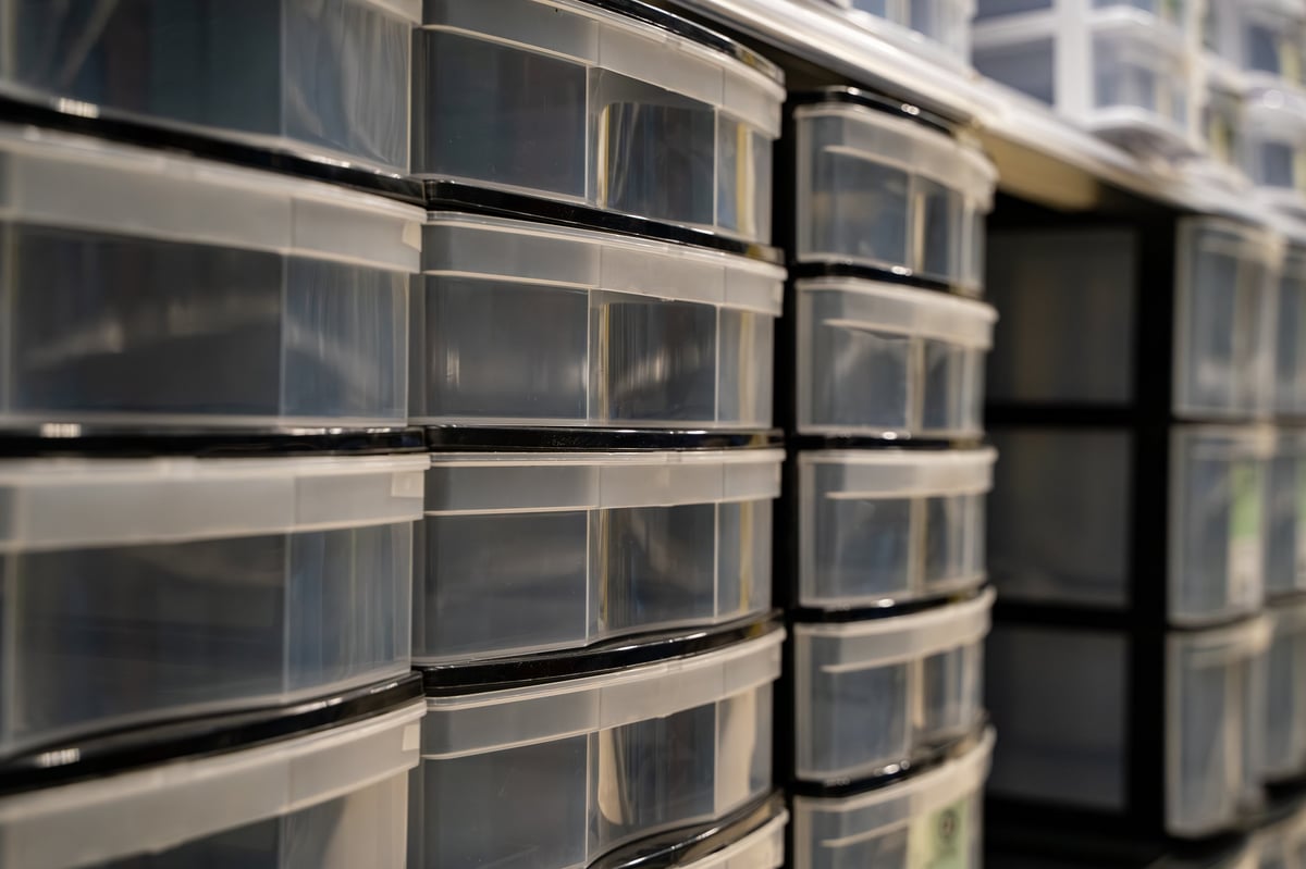 Plastic storage drawer organizers neatly arranged on a shelf in a hardware store